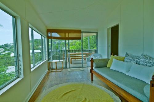 a living room with a couch and some windows at Rosemaree, 24 East Street in Crescent Head