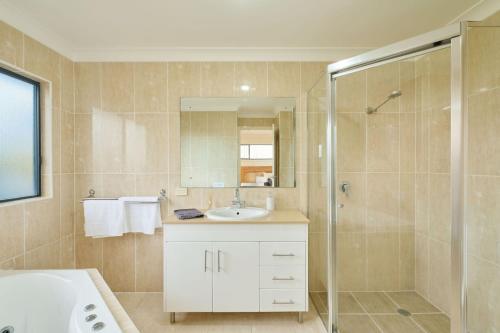 a bathroom with a sink and a shower at Riverside Luxury in Port Macquarie