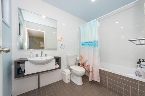 a white bathroom with a sink and a toilet at Sandy Shores, Serenity Resort in Diamond Beach