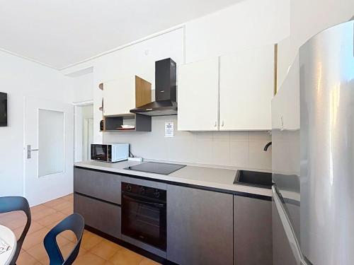 a kitchen with white cabinets and a stove top oven at Apartment Ca dei Noni by Interhome in Riva del Garda