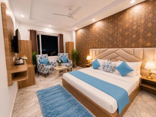 a hotel room with a bed and two chairs at Hotel LA Meridian, A Luxury Hotel In Haridwar in Haridwār