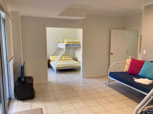 a living room with a couch and a bunk bed at Vaka Malua, 7 Scott Street in Crescent Head