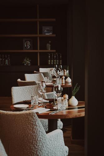 a wooden table with chairs and wine glasses on it at Aktiv & Spa Hotel Alpenrose in Schruns