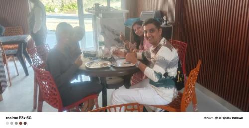 a man and woman sitting at a table eating food at Hotel Kalyan Palace And Restaurant in Pīpalkoti