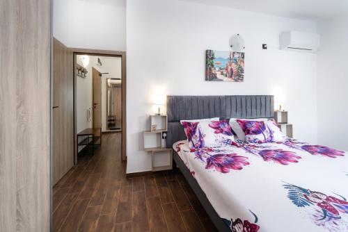 a bedroom with a large bed and a hallway at Transilvaniya Apartments in Sozopol