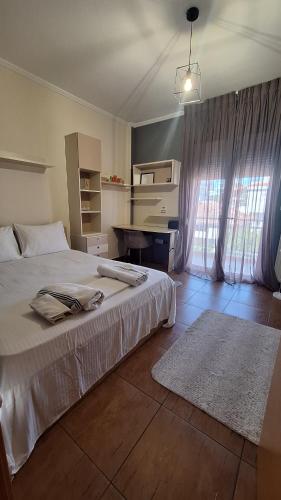 a bedroom with a bed and a desk in it at Persefoni 's hause 1 in Nea Kallikrateia