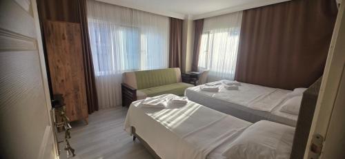 a hotel room with two beds and a chair at Blue Amedist Hotel in Istanbul