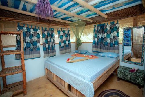 a bedroom with a bed with a ladder and windows at Peace House Zanzibar in Bwejuu