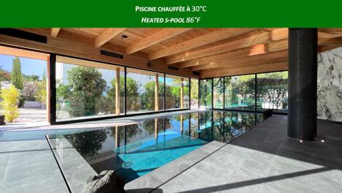 an indoor swimming pool in a house with glass windows at Campo Di Fiori, Maisons de Charme in Calvi