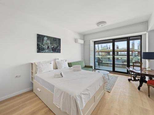 a white bedroom with a large bed and a desk at Tomis Villa Grand Resort in Mamaia Sat/Năvodari
