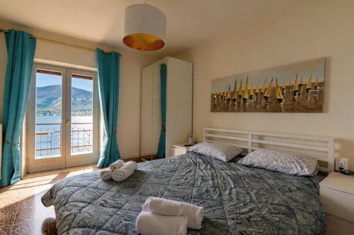 a bedroom with a large bed and a large window at Apartment Di Lago by GardaDoma in Brenzone sul Garda