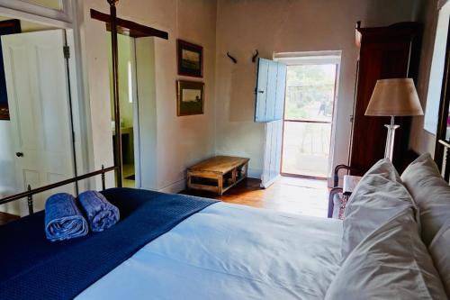 a bedroom with a bed and a couch and a window at Doornkraal Farm in De Rust