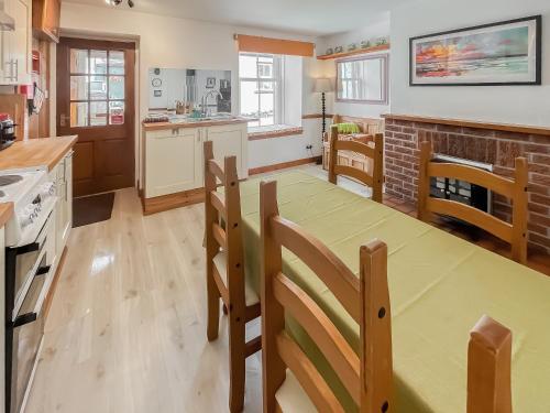 a kitchen with a table and chairs in a kitchen at 10 The Apostles - Uk37312 in Lochranza