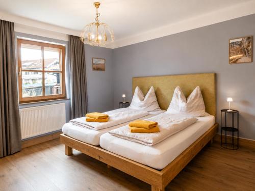 a bedroom with two beds and a chandelier at Toms ONE in Saalfelden am Steinernen Meer