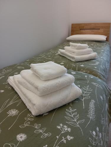 three white towels sitting on top of a bed at Il rifugio del cuore in San Massimo