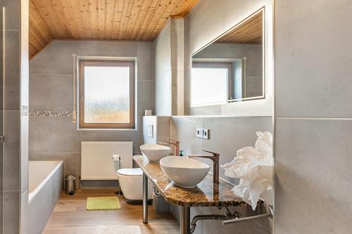 a bathroom with two sinks and a tub at Work&Travel-Pension Tobias in Selb