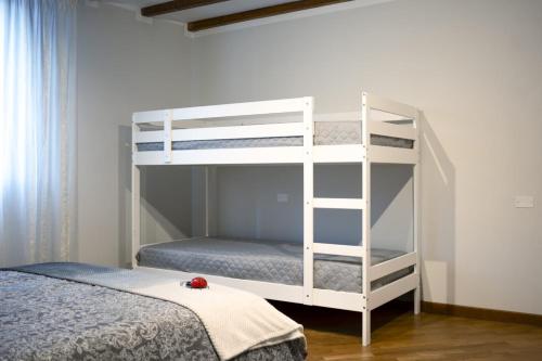 a white bunk bed with a ladder next to a bed at HOLIDAY HOUSE LE COCCINELLE in Salò