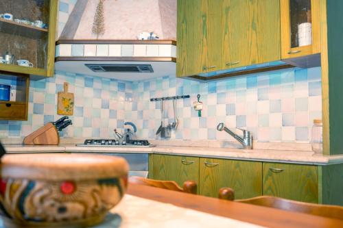 a kitchen with wooden cabinets and a sink and a counter at HOLIDAY HOUSE LE COCCINELLE in Salò