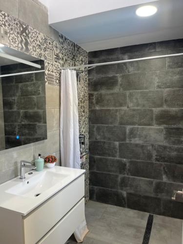 a bathroom with a sink and a stone wall at Pozo, 22 in Fuente Palmera