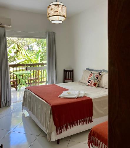 a bedroom with a bed with a red blanket on it at D'Ajuda Inn in Arraial d'Ajuda
