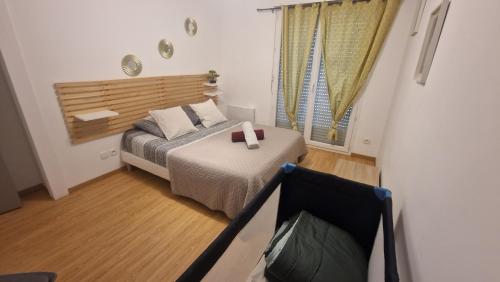 a small bedroom with a bed and a window at Maison le palmier in Troarn