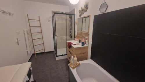 a bathroom with a tub and a sink and a shower at Maison le palmier in Troarn