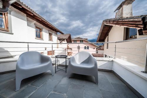 two chairs and a table on a balcony at Apartment Das Goldgassl in Appiano sulla Strada del Vino