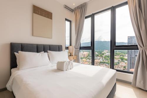 a white bed in a room with large windows at 22 Macalisterz by YourSuperhost in George Town