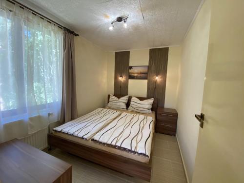a small bedroom with a bed and a window at Bungalow Park Balatonboglár in Balatonboglár
