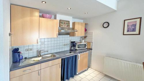 a kitchen with a sink and a microwave at Villa Vivien, Ostsee Findling App 4 - Bade- & Saunawelt täglich inklusive in Göhren