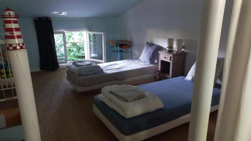 a bedroom with two bunk beds and a window at La Bouee, entre Manche et Seine in Saint-Nicolas-de-la-Haie