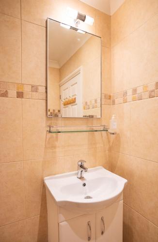 a bathroom with a sink and a mirror at The Cottage Hankerton Priory in Hankerton