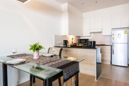 a kitchen with a table and a counter top at Somerset Park Suanplu Bangkok in Bangkok