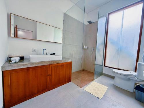 a bathroom with a sink and a toilet and a mirror at Villa Leyan 1 Semer - Between Seminyak & Canggu in Seminyak