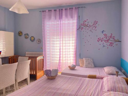 a bedroom with a bed and a window with flowers on the wall at Appartamento Nonna Ida in Montesarchio