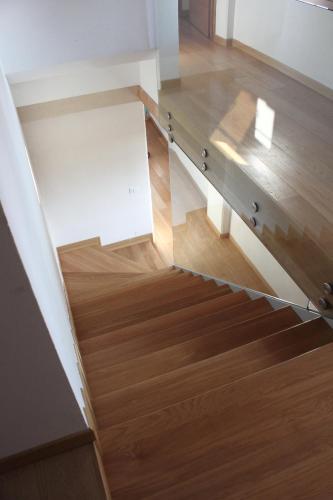 a staircase with a glass railing and wooden floor at Caspineda Agriturismo in Montebelluna