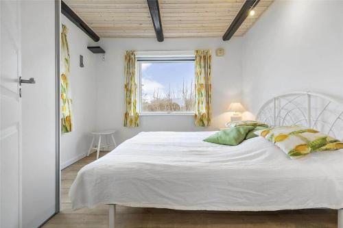 a bedroom with a white bed and a window at 12231-Sjaellands-Odde-Rogerivej-2 in Havnebyen