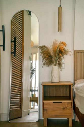 a room with a mirror and a dresser with a plant at Beach Terrace Studio - WaveSide Ocean Bliss in Thong Sala