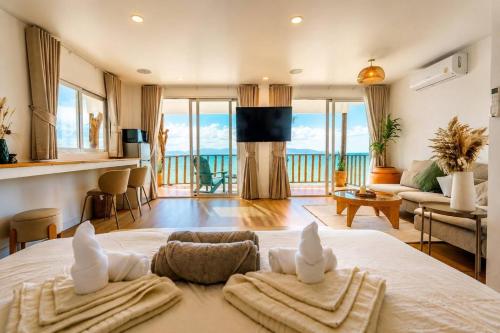 a bedroom with a large bed with towels on it at Beach Terrace Studio - WaveSide Ocean Bliss in Thong Sala
