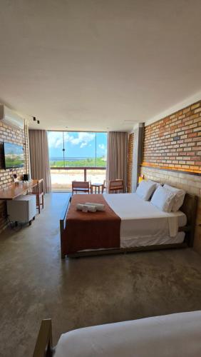a large bedroom with a large bed and a desk at Pousada Don Ruan in Tutóia