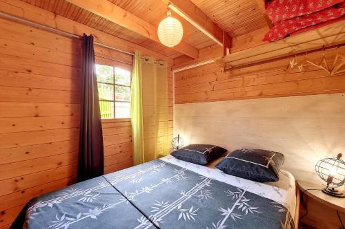 a bedroom with a bed in a log cabin at Le Yucca - Terrasse et jardin - Wifi in Saint-Louis