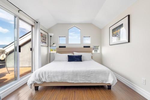 a white bedroom with a large bed and windows at Family-Friendly 3BR Home in Vancouver