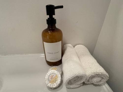 a bottle of soap next to towels and a clock at Apartments Miami in Sunny Isles Beach