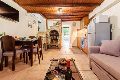 a kitchen and living room with a table and a refrigerator at Petalidi Olive Garden Stone House near the beach in Petalidi