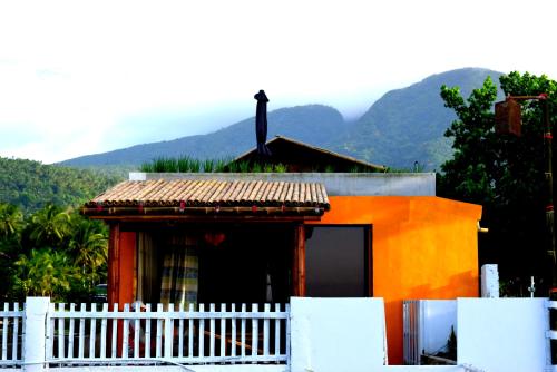 a small house with a white fence in front of it at Guerrera Rice Paddy Villas in Mambajao
