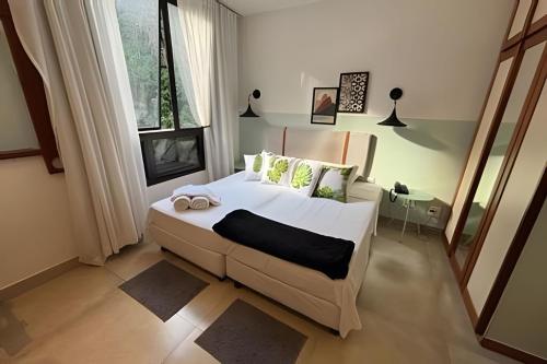 a bedroom with a large white bed and a window at Hotel Residence in Rio de Janeiro
