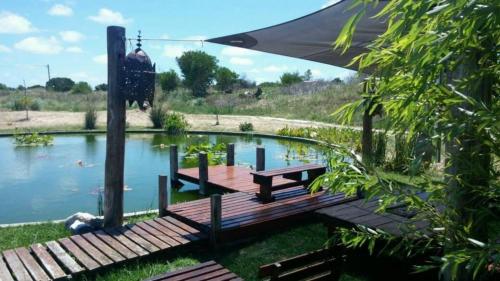 a wooden dock with a picnic table next to a pond at Las Rosas in Mar Azul