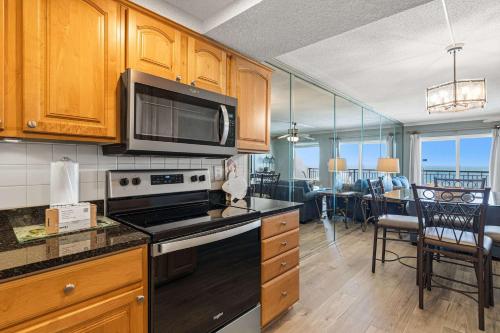 a kitchen with a stove and a microwave at Seventh-floor oceanfront condo with pool access ocean view & central AC in Fort Walton Beach