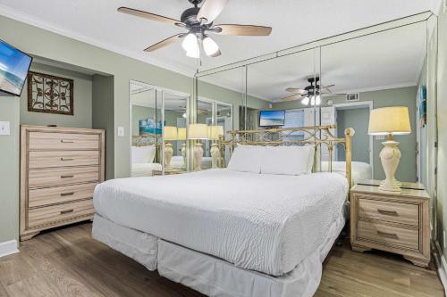 a bedroom with a bed and a large mirror at Seventh-floor oceanfront condo with pool access ocean view & central AC in Fort Walton Beach