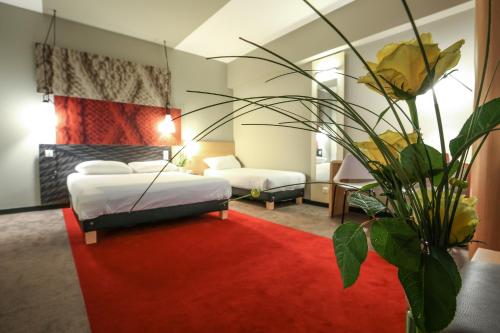 um quarto de hotel com duas camas e um tapete vermelho em Ibis Niort Est Mendes France em Niort